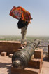 Tourist with flowing red shawl on a cannon in Jodhpur fort